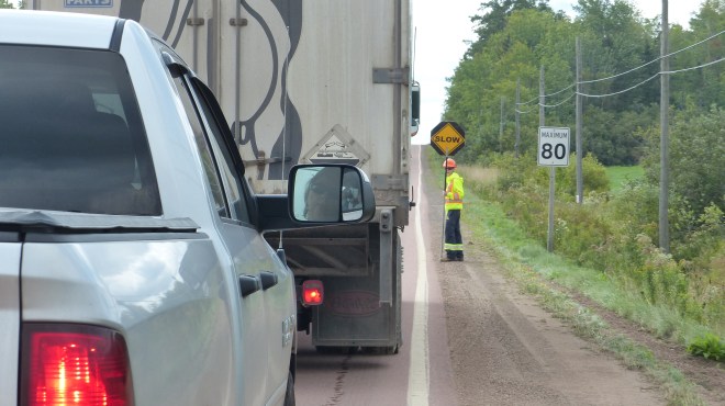 Kanadische Straßenbaustelle: Vorn und hinten je einer, der ein Stop / Slow - Schild hält und dann dreht, wenn man weiter darf. Langsam! 